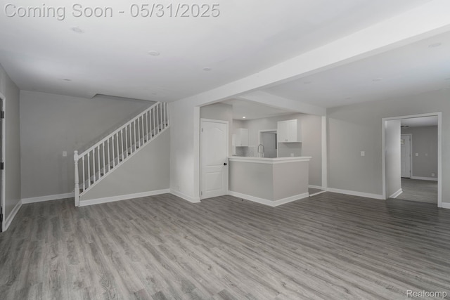 16565 Winston St, Detroit, MI 48219 - unfurnished living room featuring stairway, wood finished floors, and baseboards