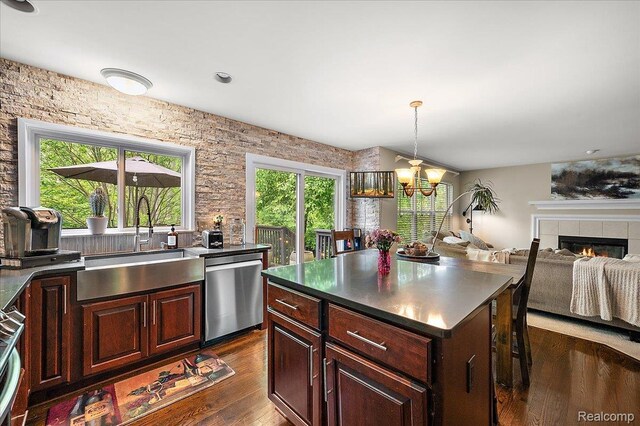 3796 Briarbrooke Ln, Rochester, MI 48306 - kitchen featuring dishwasher, a sink, dark wood finished floors, a chandelier, and a tiled fireplace