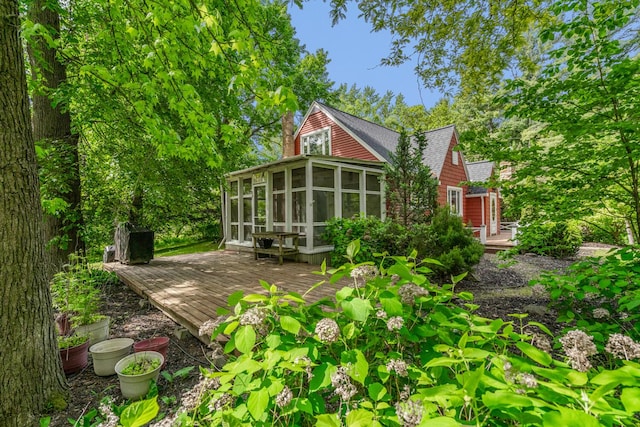 7938 E Dr N, Battle Creek, MI 49014 - rear view of property featuring a sunroom, a wooden deck, and a shingled roof