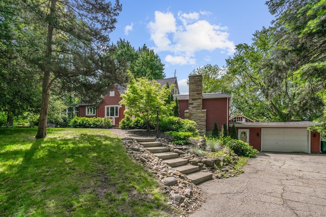 7938 E Dr N, Battle Creek, MI 49014 - view of front of property featuring asphalt driveway, a garage, a front yard, and a chimney
