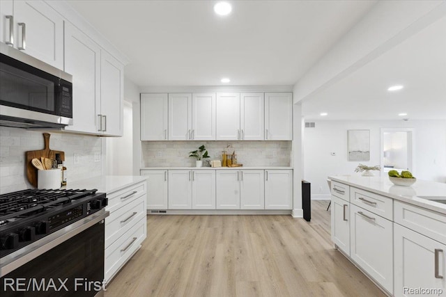 31111 Angeline Ct E, Saint Clair Shores, MI 48082 - kitchen with stainless steel microwave, range with gas cooktop, recessed lighting, light countertops, and white cabinets