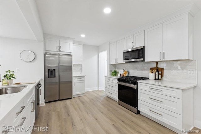 31111 Angeline Ct E, Saint Clair Shores, MI 48082 - kitchen with appliances with stainless steel finishes, backsplash, white cabinets, light wood-style floors, and light countertops
