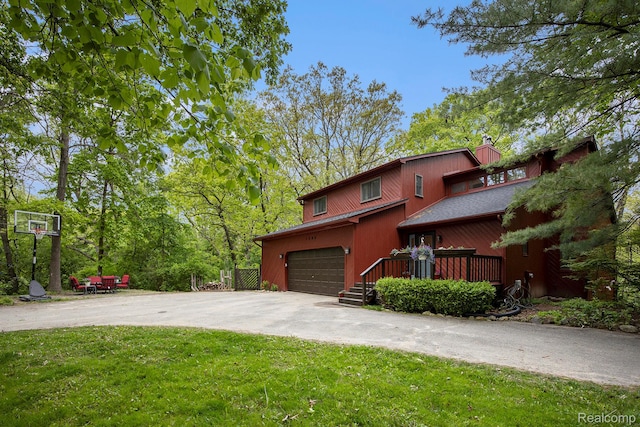 1295 Kern Rd, Oakland, MI 48363 - view of front of house featuring an attached garage, driveway, a front lawn, and a chimney