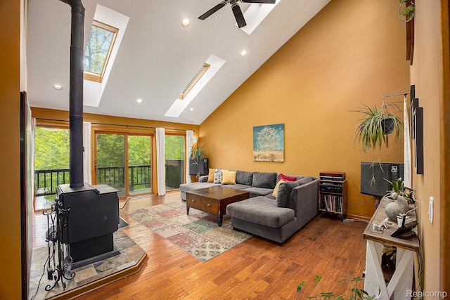 1295 Kern Rd, Oakland, MI 48363 - living area featuring a wood stove, a skylight, wood finished floors, high vaulted ceiling, and ceiling fan