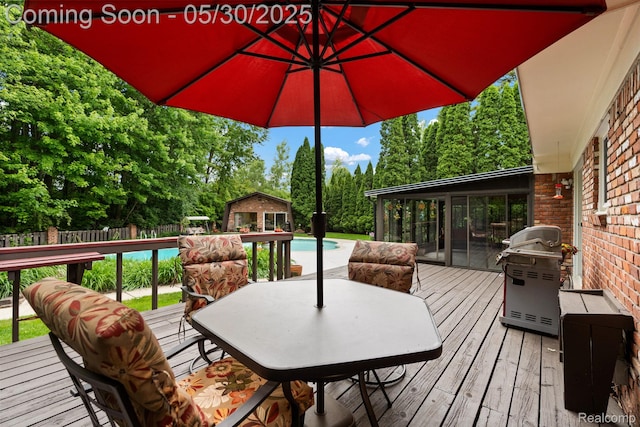 9495 Continental Dr, Taylor, MI 48180 - wooden deck featuring grilling area, an outdoor pool, an outbuilding, view of wooded area, and outdoor dining area