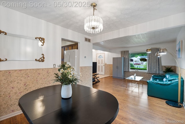 9495 Continental Dr, Taylor, MI 48180 - dining area with a chandelier, wood finished floors, and a textured ceiling