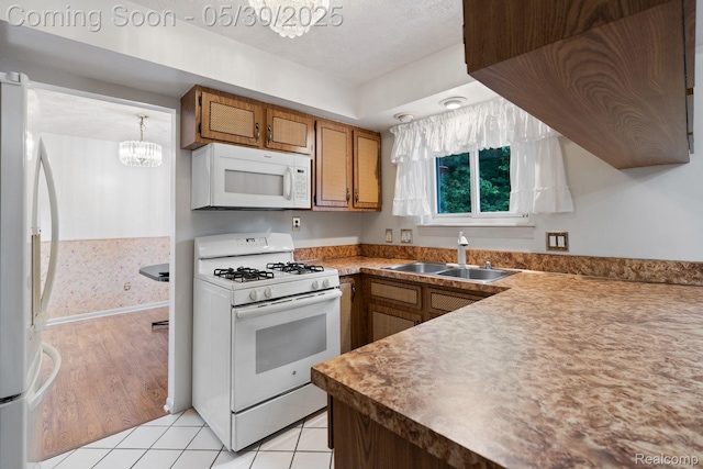 9495 Continental Dr, Taylor, MI 48180 - kitchen featuring white appliances, a sink, a chandelier, brown cabinets, and light tile patterned floors