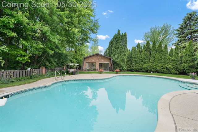 9495 Continental Dr, Taylor, MI 48180 - view of swimming pool with an outbuilding, a patio, and view of wooded area