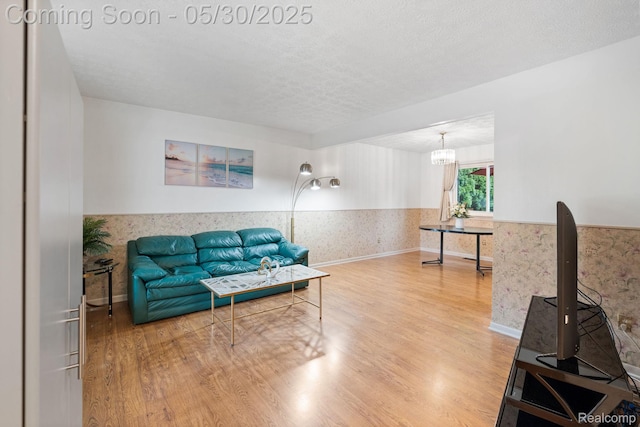 9495 Continental Dr, Taylor, MI 48180 - living room featuring wood finished floors, wainscoting, a chandelier, a textured ceiling, and baseboards