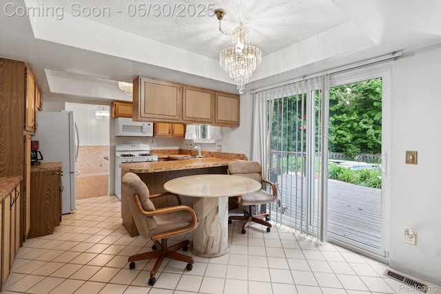 9495 Continental Dr, Taylor, MI 48180 - kitchen featuring white appliances, a sink, a peninsula, a chandelier, and a tray ceiling