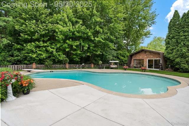 9495 Continental Dr, Taylor, MI 48180 - view of pool featuring a patio area, a diving board, and view of wooded area
