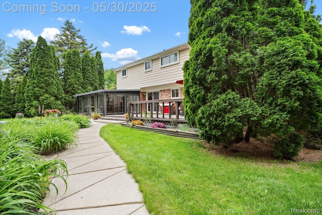 9495 Continental Dr, Taylor, MI 48180 - back of house with a yard, brick siding, a deck, and a sunroom