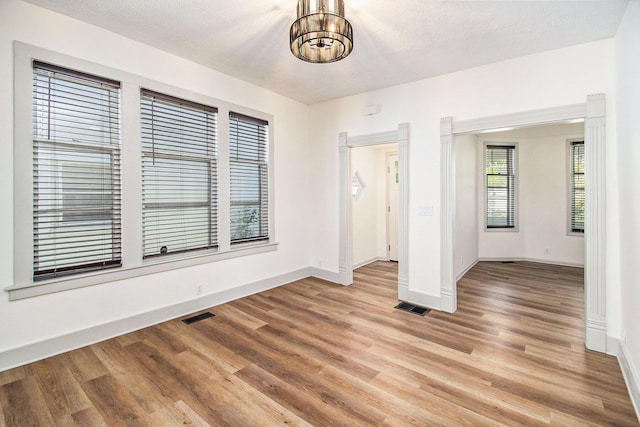 224 Spencer St NE, Grand Rapids, MI 49505 - spare room featuring a chandelier, baseboards, and light wood-style flooring