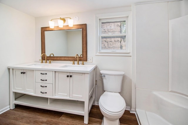 224 Spencer St NE, Grand Rapids, MI 49505 - full bathroom featuring wood finished floors, double vanity, toilet, and baseboards