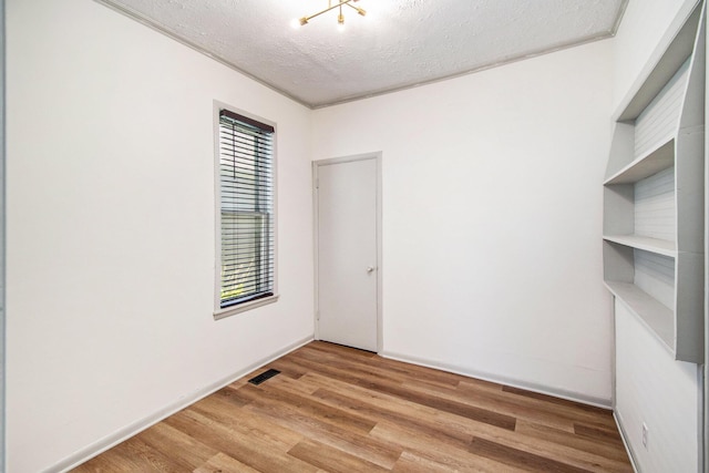 224 Spencer St NE, Grand Rapids, MI 49505 - spare room featuring a textured ceiling and wood finished floors