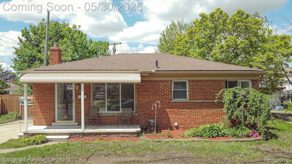 24855 Melody Rd, Warren, MI 48089 - view of front of house featuring brick siding, a chimney, roof with shingles, and covered porch