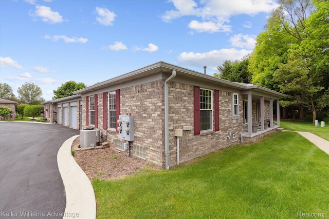 48727 Aberdeen Ct, Shelby Twp, MI 48315 - view of property exterior featuring a yard, driveway, central AC unit, and brick siding