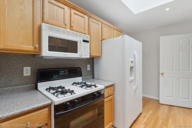 48727 Aberdeen Ct, Shelby Twp, MI 48315 - kitchen featuring white appliances, a skylight, light countertops, light wood-style flooring, and backsplash