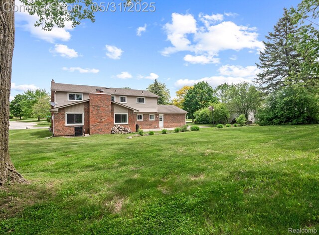 1916 Squirrel Valley Dr, Bloomfield Hills, MI 48304 - back of property featuring brick siding, a chimney, and a lawn
