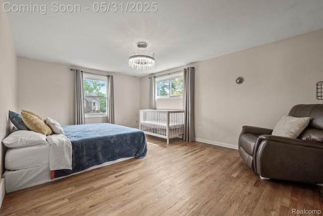 1916 Squirrel Valley Dr, Bloomfield Hills, MI 48304 - bedroom featuring wood finished floors, multiple windows, a chandelier, and baseboards