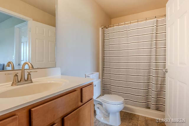 709 Wild Flower Dr, Wayland, MI 49348 - bathroom featuring vanity, toilet, curtained shower, and stone finish floors