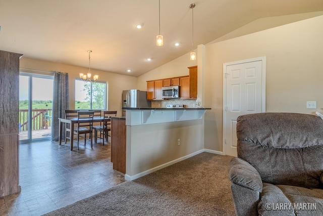 709 Wild Flower Dr, Wayland, MI 49348 - kitchen featuring appliances with stainless steel finishes, brown cabinetry, dark countertops, lofted ceiling, and a kitchen bar
