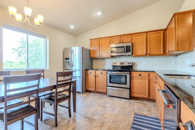 709 Wild Flower Dr, Wayland, MI 49348 - kitchen with appliances with stainless steel finishes, lofted ceiling, a sink, decorative backsplash, and a chandelier
