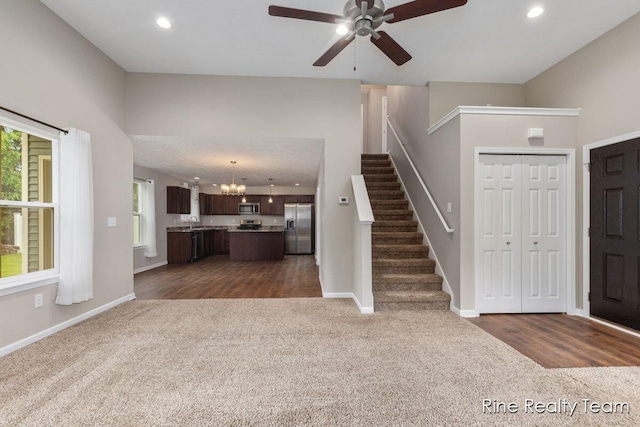4335 Norway St, Holt, MI 48842 - foyer with dark colored carpet, ceiling fan, a chandelier, stairway, and baseboards