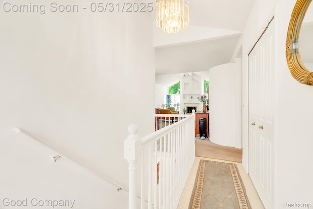 48757 Tilford Ct, Shelby Twp, MI 48315 - hallway featuring lofted ceiling, a chandelier, an upstairs landing, inlaid floor details, and light tile patterned flooring