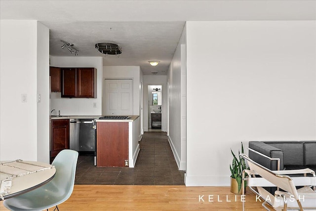 505 Cherry St SE Unit 612, Grand Rapids, MI 49503 - kitchen featuring dishwashing machine, dark tile patterned flooring, dark brown cabinets, a sink, and light countertops