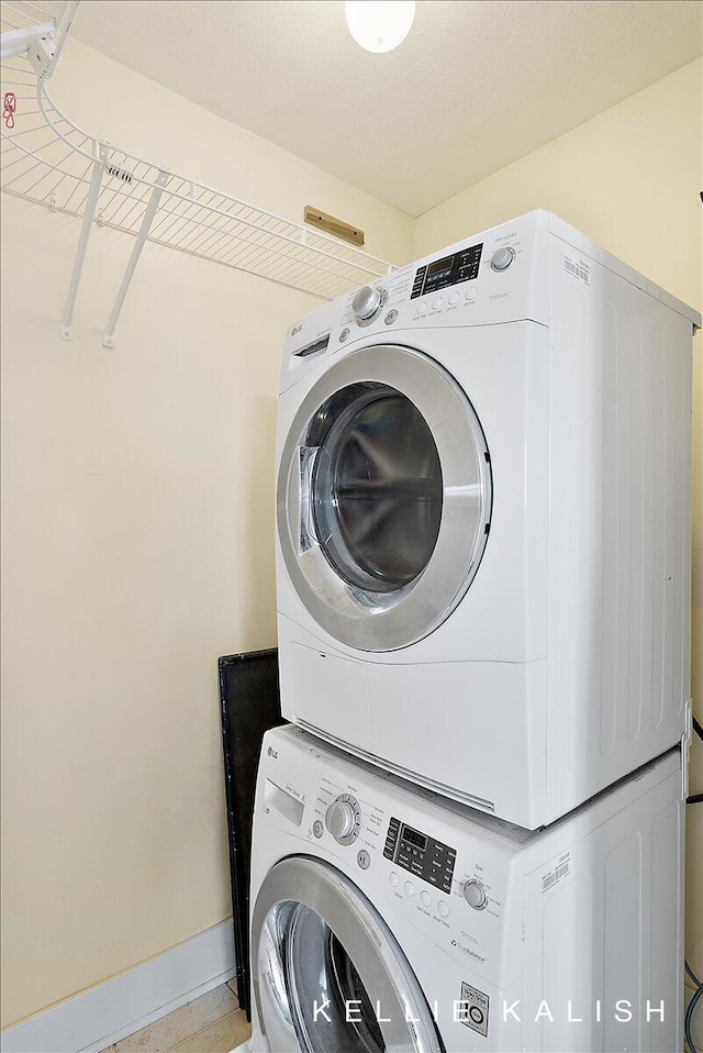 505 Cherry St SE Unit 612, Grand Rapids, MI 49503 - laundry area with stacked washing machine and dryer and baseboards