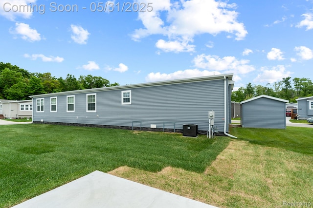 8551 Boyer Dr, Willis, MI 48191 - back of property featuring a lawn, central AC unit, and a patio area