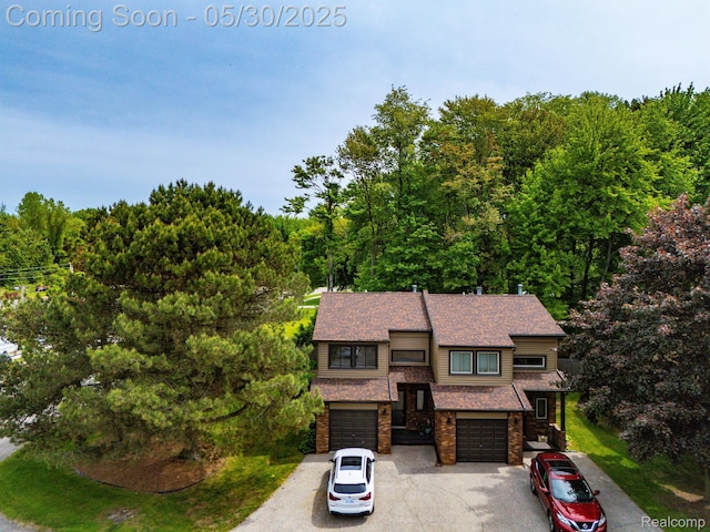 50820 Marsha Ln, New Baltimore, MI 48047 - view of front facade featuring concrete driveway, an attached garage, a wooded view, and brick siding
