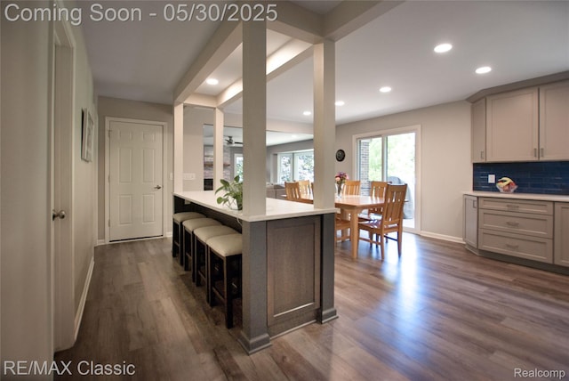 44500 Louvert Ct, Novi, MI 48375 - kitchen featuring baseboards, light countertops, recessed lighting, dark wood-style flooring, and a breakfast bar