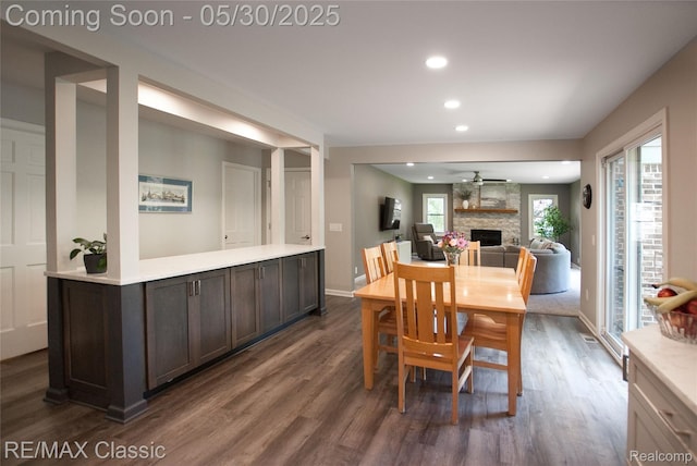 44500 Louvert Ct, Novi, MI 48375 - dining space with dark wood-style floors, a stone fireplace, recessed lighting, ceiling fan, and baseboards