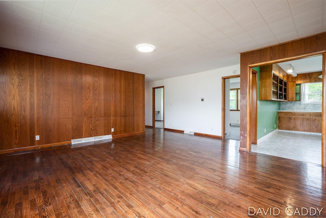 9081 E Baker Rd, Hesperia, MI 49421 - empty room with hardwood / wood-style flooring, wooden walls, and baseboards
