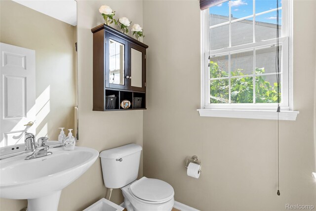 6241 Sapphire Ct, Grand Blanc, MI 48439 - half bath with plenty of natural light, toilet, a sink, and baseboards