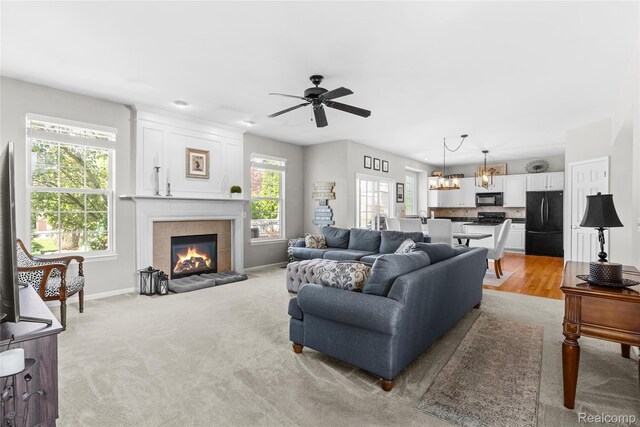 6241 Sapphire Ct, Grand Blanc, MI 48439 - living room with plenty of natural light, a tiled fireplace, a ceiling fan, and baseboards