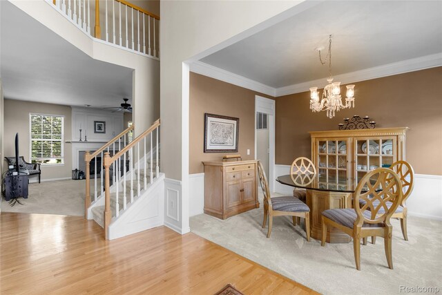 6241 Sapphire Ct, Grand Blanc, MI 48439 - dining space featuring stairs, a chandelier, light wood-style floors, ceiling fan, and light carpet