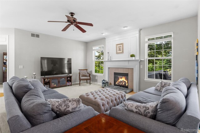 6241 Sapphire Ct, Grand Blanc, MI 48439 - living area featuring plenty of natural light, a ceiling fan, a tile fireplace, and light colored carpet
