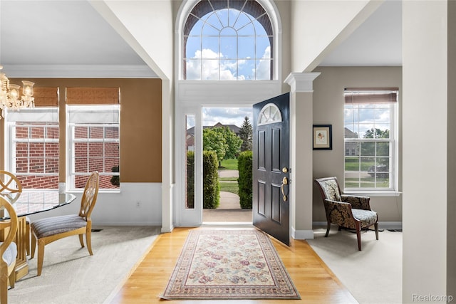 6241 Sapphire Ct, Grand Blanc, MI 48439 - foyer with a chandelier, wood finished floors, baseboards, and crown molding