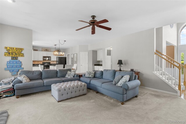 6241 Sapphire Ct, Grand Blanc, MI 48439 - living room featuring light colored carpet, ceiling fan, a chandelier, stairs, and baseboards