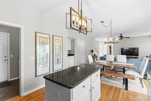 6241 Sapphire Ct, Grand Blanc, MI 48439 - kitchen with a chandelier, white cabinetry, open floor plan, and light wood-style floors