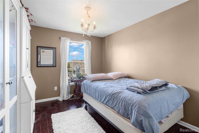 6241 Sapphire Ct, Grand Blanc, MI 48439 - bedroom with a chandelier, baseboards, and dark wood-style flooring