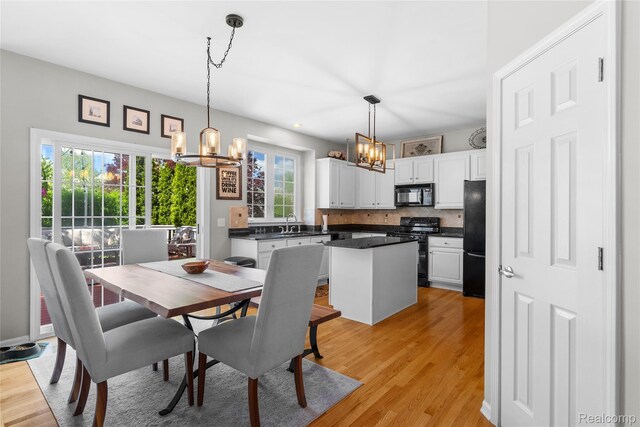 6241 Sapphire Ct, Grand Blanc, MI 48439 - dining room featuring a chandelier and light wood-style floors