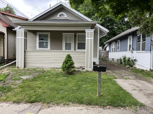 1008 S Holmes St, Lansing, MI 48912 - shotgun-style home with a front yard and covered porch