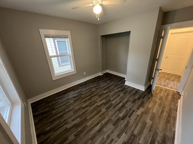 1008 S Holmes St, Lansing, MI 48912 - unfurnished bedroom featuring dark wood-style flooring, baseboards, a closet, and a ceiling fan