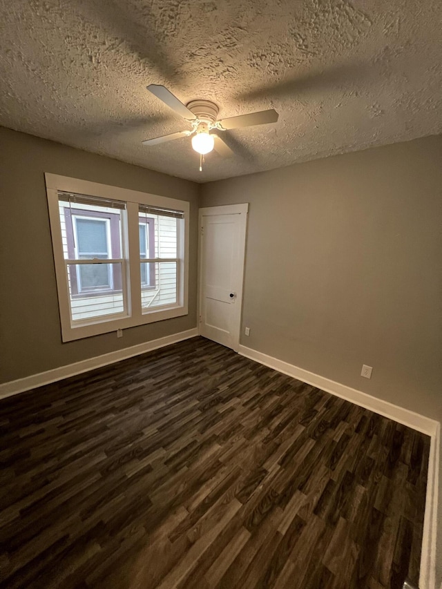 1008 S Holmes St, Lansing, MI 48912 - spare room with dark wood finished floors, baseboards, ceiling fan, and a textured ceiling
