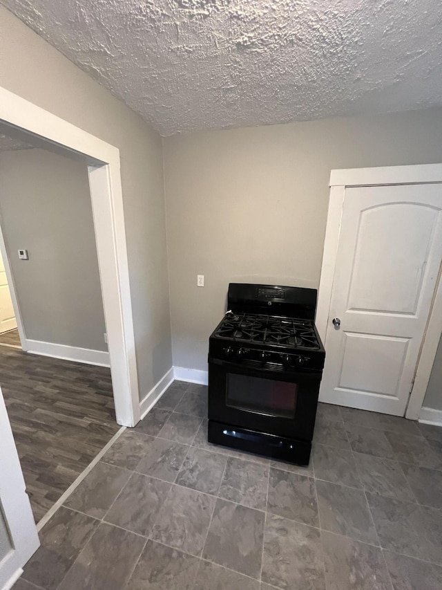 1008 S Holmes St, Lansing, MI 48912 - kitchen featuring black range with gas cooktop, a textured ceiling, baseboards, and tile patterned floors