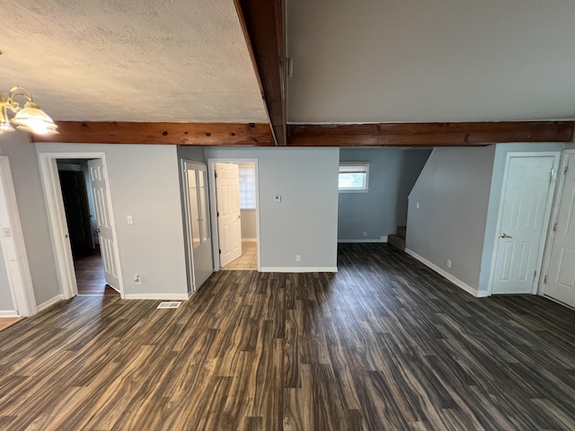 937 S Holmes St, Lansing, MI 48912 - unfurnished living room with beamed ceiling, baseboards, dark wood-type flooring, and a textured ceiling